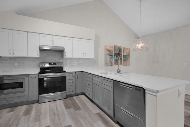 3712 E Links Cir, Hilliard, OH 43026 - kitchen with stainless steel appliances, under cabinet range hood, gray cabinets, a peninsula, and a chandelier