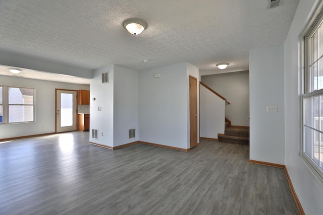 1852 Meadowlawn Dr, Columbus, OH 43219 - unfurnished room with wood finished floors, a textured ceiling, healthy amount of natural light, and stairway