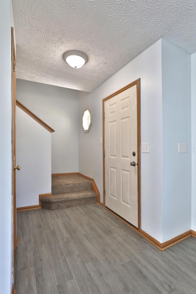 1852 Meadowlawn Dr, Columbus, OH 43219 - entryway featuring stairway, wood finished floors, and a textured ceiling