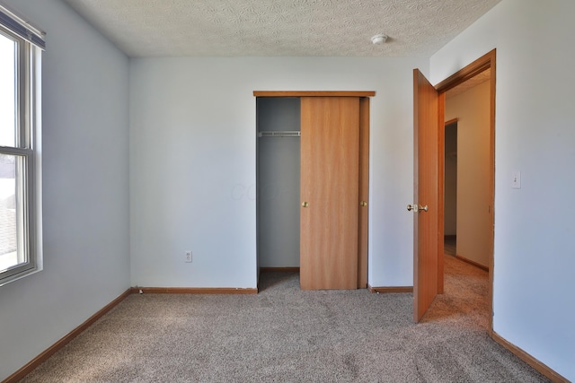 1852 Meadowlawn Dr, Columbus, OH 43219 - unfurnished bedroom featuring multiple windows, carpet floors, a closet, and a textured ceiling