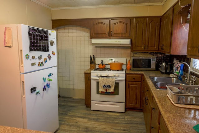 72 S Oakley Ave, Columbus, OH 43204 - kitchen with white appliances, under cabinet range hood, dark wood-type flooring, ornamental molding, and tasteful backsplash