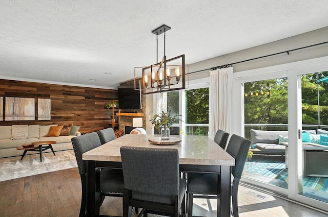 96 Executive Ct Unit B, Westerville, OH 43081 - dining room featuring wooden walls, a chandelier, dark wood-style flooring, and a textured ceiling