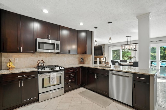 96 Executive Ct Unit B, Westerville, OH 43081 - kitchen with stainless steel appliances, a peninsula, healthy amount of natural light, decorative backsplash, and a textured ceiling
