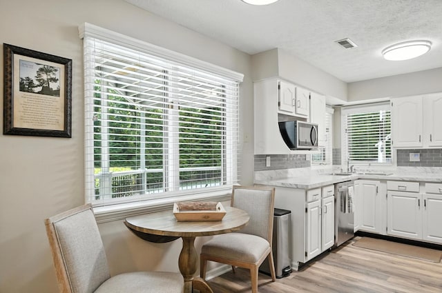 96 Executive Ct Unit B, Westerville, OH 43081 - kitchen with appliances with stainless steel finishes, white cabinetry, light wood finished floors, tasteful backsplash, and a textured ceiling