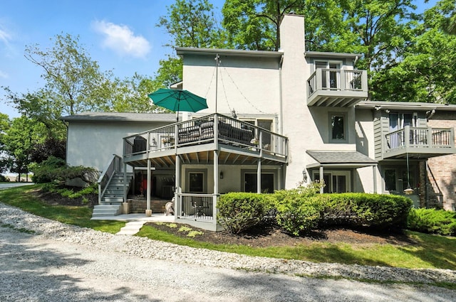 96 Executive Ct Unit B, Westerville, OH 43081 - rear view of property with stucco siding, a chimney, a balcony, and stairs
