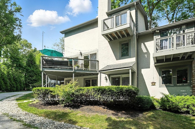 96 Executive Ct Unit B, Westerville, OH 43081 - view of side of property with a balcony, stucco siding, and a chimney