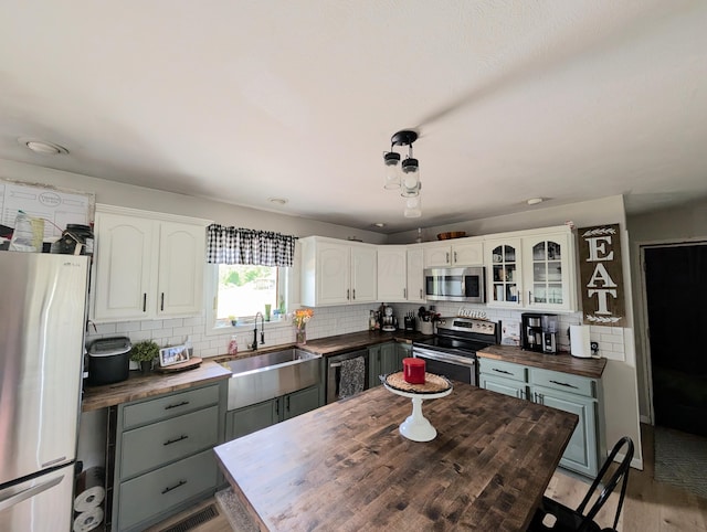 3439 Rough And Ready Rd, New Concord, OH 43762 - kitchen with butcher block countertops, appliances with stainless steel finishes, backsplash, and white cabinetry
