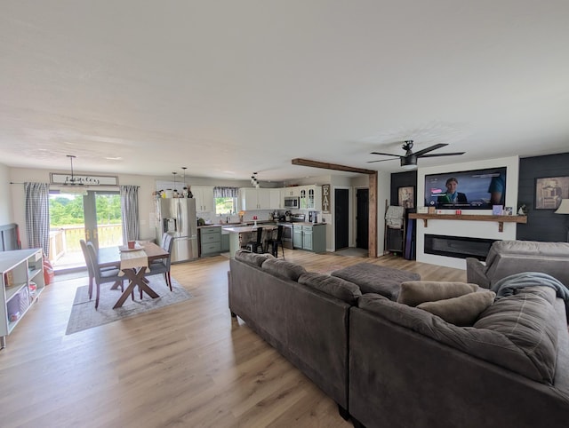 3439 Rough And Ready Rd, New Concord, OH 43762 - living room featuring light wood-style floors, ceiling fan, and a glass covered fireplace