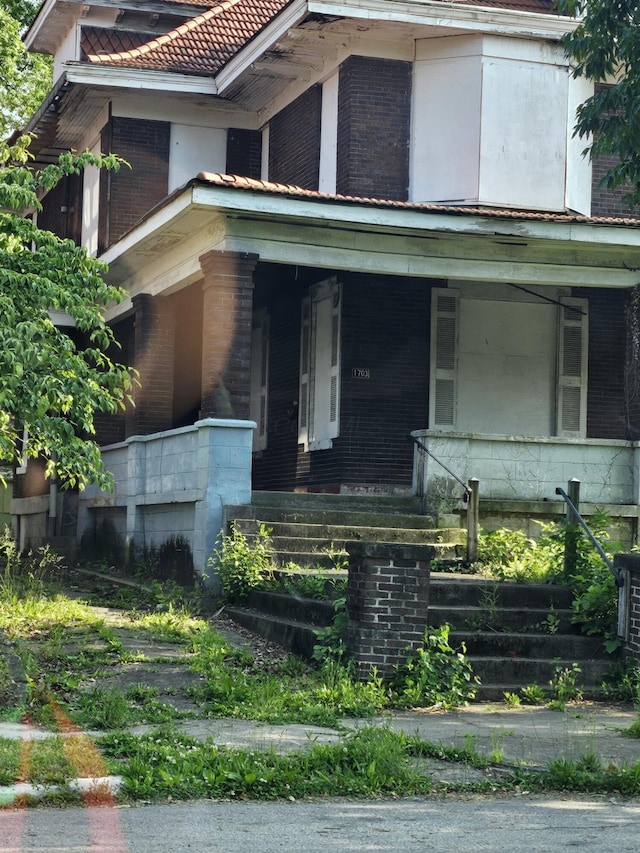 1703 Bryden Rd, Columbus, OH 43205 - view of front of property with brick siding, a porch, and a tile roof