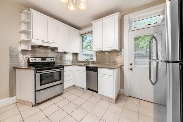 675-677 Beech St, Columbus, OH 43206 - kitchen featuring appliances with stainless steel finishes, under cabinet range hood, healthy amount of natural light, and open shelves