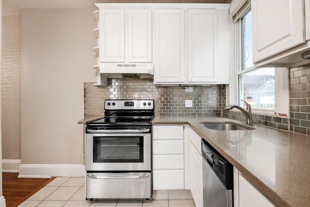 675-677 Beech St, Columbus, OH 43206 - kitchen with stainless steel appliances, under cabinet range hood, white cabinetry, open shelves, and light stone counters