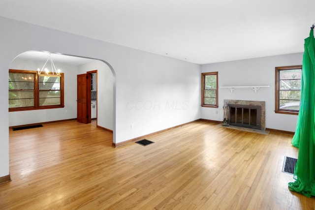 206 Lintner St, Columbus, OH 43230 - unfurnished living room with arched walkways, light wood-style floors, and a fireplace