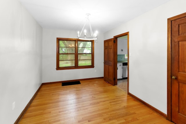 206 Lintner St, Columbus, OH 43230 - empty room featuring light wood-type flooring and a chandelier