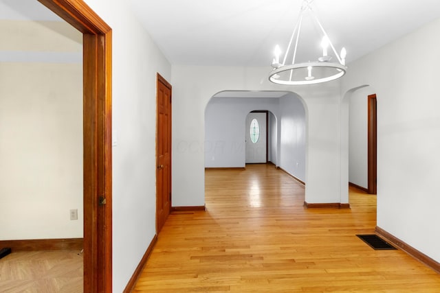 206 Lintner St, Columbus, OH 43230 - corridor with arched walkways, a chandelier, and light wood finished floors
