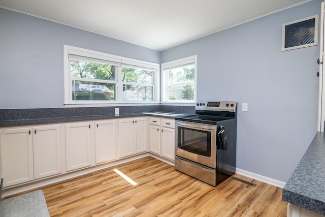 922 Afton Rd, Columbus, OH 43221 - kitchen featuring stainless steel electric range oven, light wood-style flooring, dark countertops, and crown molding