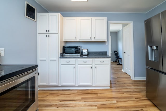 922 Afton Rd, Columbus, OH 43221 - kitchen with stainless steel appliances, dark countertops, light wood finished floors, white cabinetry, and ornamental molding