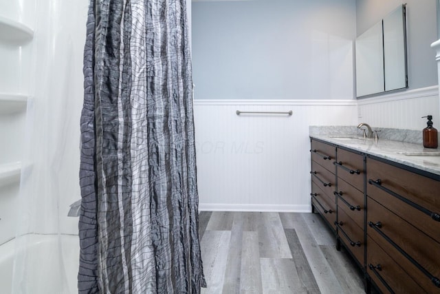 922 Afton Rd, Columbus, OH 43221 - full bathroom with wood finished floors, a wainscoted wall, double vanity, and shower / bath combo