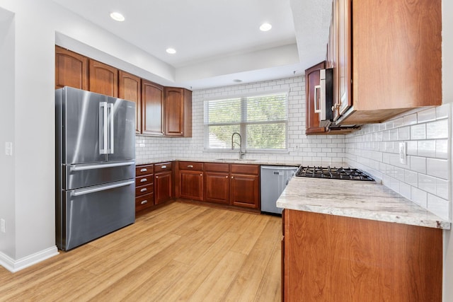 4884 Alston Grove Dr, Westerville, OH 43082 - kitchen featuring appliances with stainless steel finishes, light wood finished floors, decorative backsplash, recessed lighting, and light stone countertops