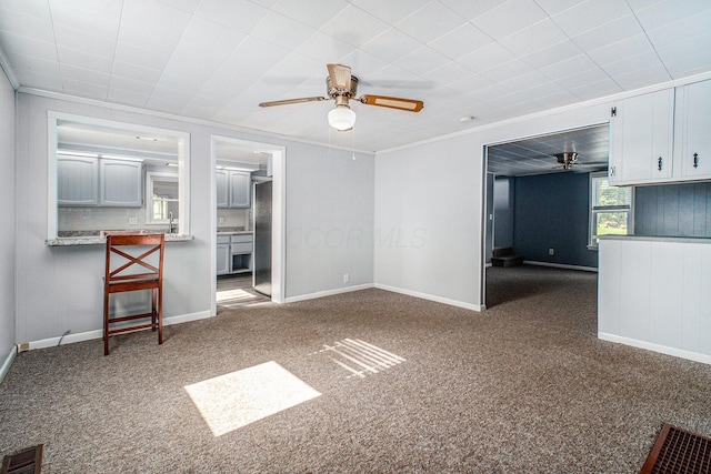 2883 Tucker Rd, Lucas, OH 44843 - unfurnished living room featuring ceiling fan, carpet flooring, and crown molding