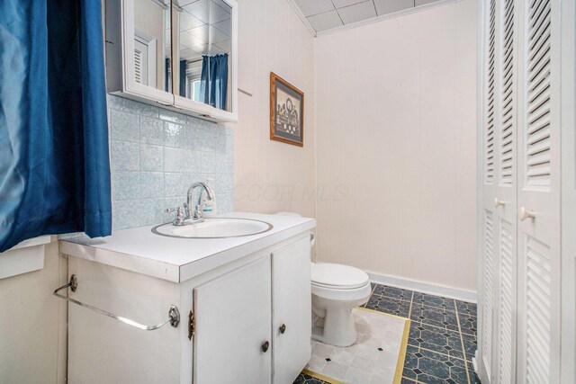 2883 Tucker Rd, Lucas, OH 44843 - bathroom with a closet, vanity, crown molding, and tasteful backsplash