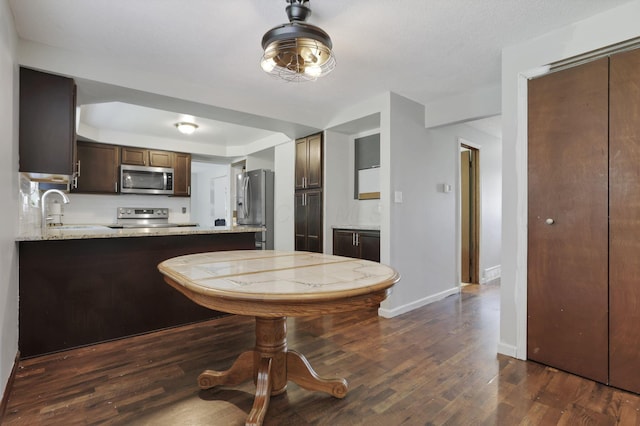 372 Depauw Ct, Columbus, OH 43230 - kitchen featuring stainless steel appliances, dark wood-style flooring, dark brown cabinets, and a peninsula