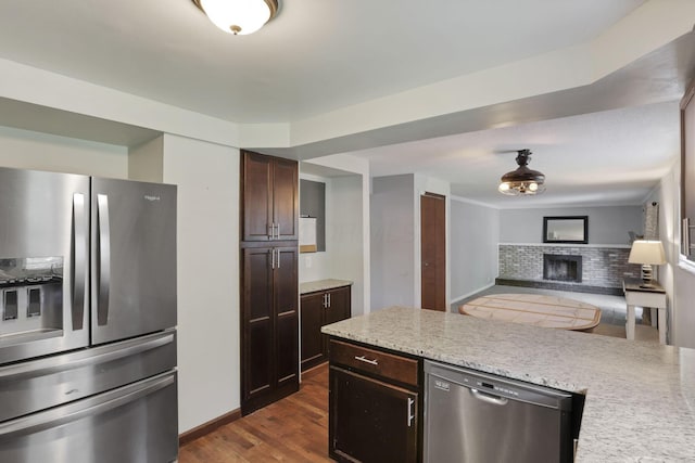 372 Depauw Ct, Columbus, OH 43230 - kitchen with appliances with stainless steel finishes, a fireplace, dark brown cabinets, dark wood-type flooring, and open floor plan