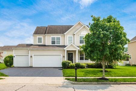 1883 Caplinger Dr, Grove City, OH 43123 - view of front facade with asphalt driveway, a front yard, and an attached garage