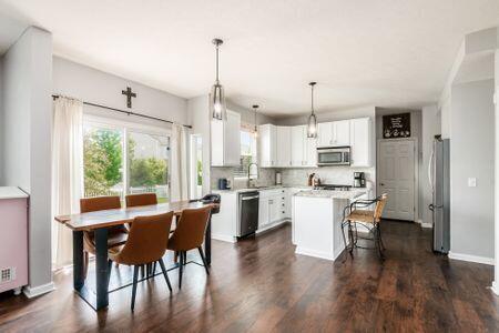 1883 Caplinger Dr, Grove City, OH 43123 - kitchen featuring appliances with stainless steel finishes, white cabinets, a kitchen island, light countertops, and a kitchen bar