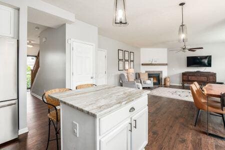 1883 Caplinger Dr, Grove City, OH 43123 - kitchen with stainless steel refrigerator, a lit fireplace, dark wood finished floors, and ceiling fan