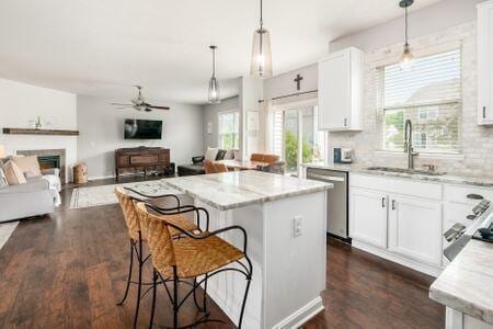 1883 Caplinger Dr, Grove City, OH 43123 - kitchen with dishwasher, a kitchen island, light stone countertops, open floor plan, and ceiling fan