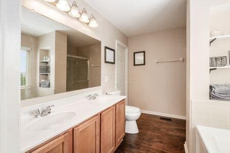 1883 Caplinger Dr, Grove City, OH 43123 - full bathroom featuring a bath, double vanity, wood finished floors, and a shower