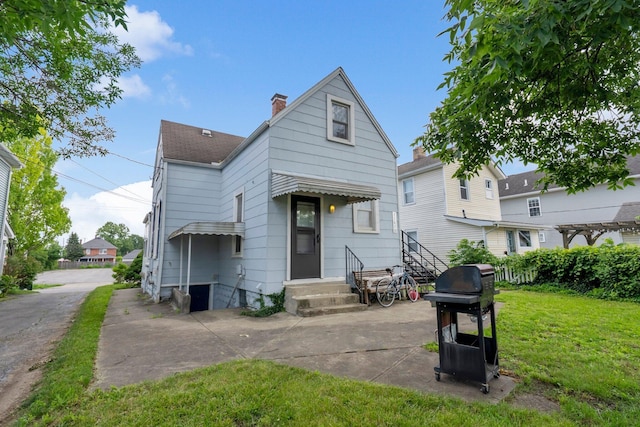 1561 Glenn Ave, Columbus, OH 43212 - back of property featuring a lawn, entry steps, a chimney, and a shingled roof