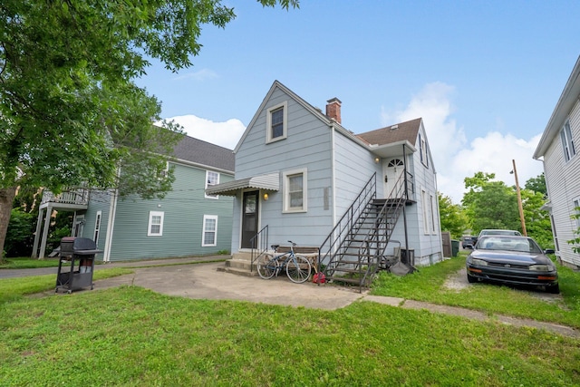 1561 Glenn Ave, Columbus, OH 43212 - rear view of house with a yard, a chimney, entry steps, and a shingled roof