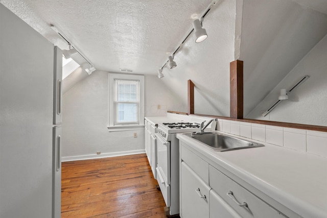 1561 Glenn Ave, Columbus, OH 43212 - kitchen featuring rail lighting, white appliances, hardwood / wood-style floors, a textured ceiling, and vaulted ceiling