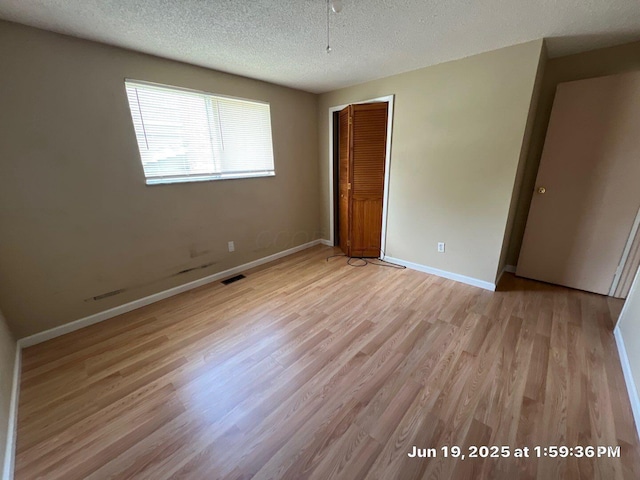 2652 Landsburn Dr, Columbus, OH 43231 - unfurnished bedroom with light wood finished floors, a closet, and a textured ceiling