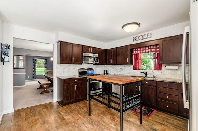 277 Mill Race Rd, Granville, OH 43023 - kitchen with stainless steel appliances, dark brown cabinetry, wood-type flooring, and decorative backsplash