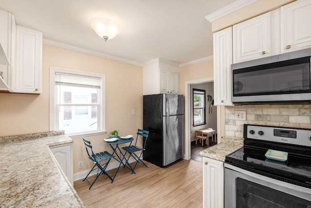 854 E Weber Rd, Columbus, OH 43211 - kitchen featuring appliances with stainless steel finishes, ornamental molding, light wood-type flooring, and white cabinets