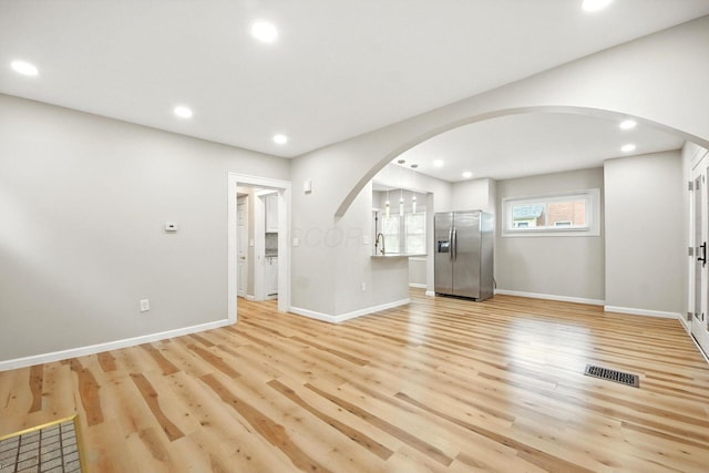 87 N Warren Ave, Columbus, OH 43204 - unfurnished living room with arched walkways, light wood-type flooring, and recessed lighting