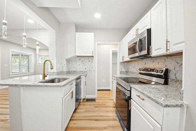 87 N Warren Ave, Columbus, OH 43204 - kitchen featuring stainless steel appliances, a peninsula, white cabinets, light wood-style flooring, and backsplash
