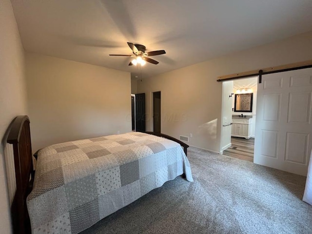 450 Village Ridge Ct, Powell, OH 43065 - bedroom with a barn door, carpet flooring, ceiling fan, and connected bathroom