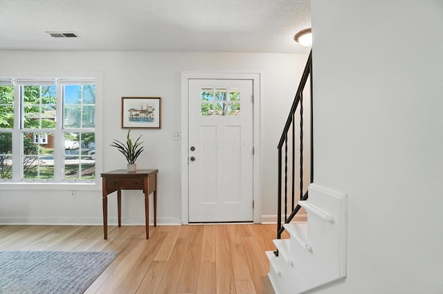 1817 Ibson Dr, Powell, OH 43065 - entrance foyer featuring stairway, light wood finished floors, plenty of natural light, and a textured ceiling
