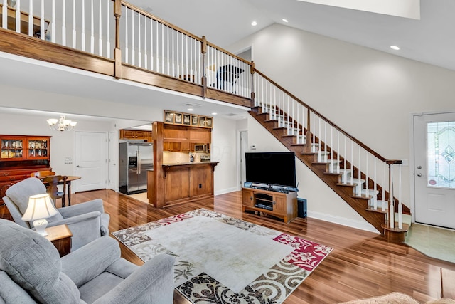 145 Glen Mawr Cir, Delaware, OH 43015 - living area featuring high vaulted ceiling, a chandelier, stairs, light wood-type flooring, and recessed lighting