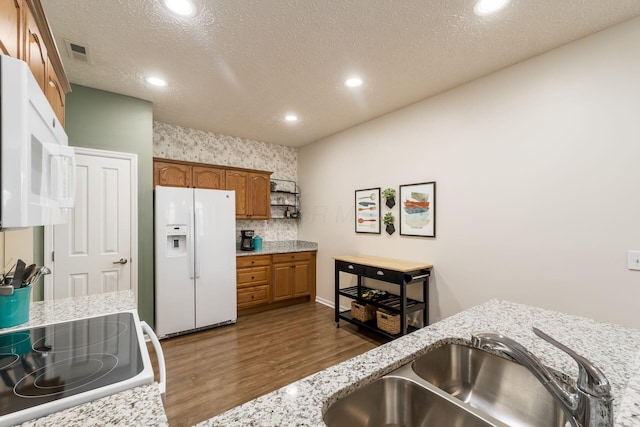 4124 Aumbrey Ct, New Albany, OH 43054 - kitchen featuring white appliances, dark wood-type flooring, brown cabinets, recessed lighting, and light stone countertops