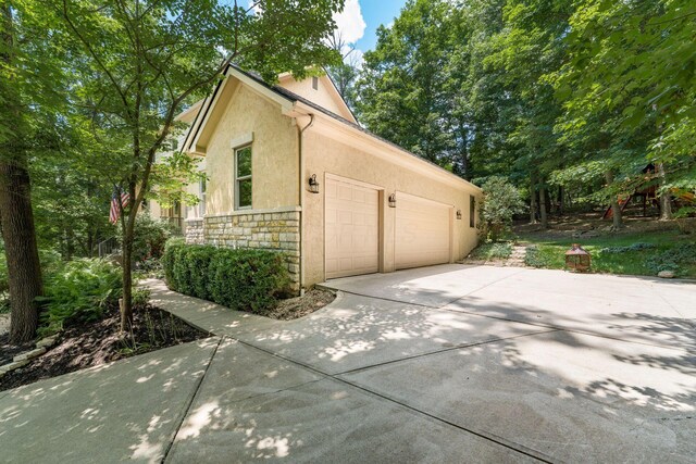 1828 Bradford Cir, Newark, OH 43055 - view of property exterior with stucco siding, stone siding, concrete driveway, and a garage