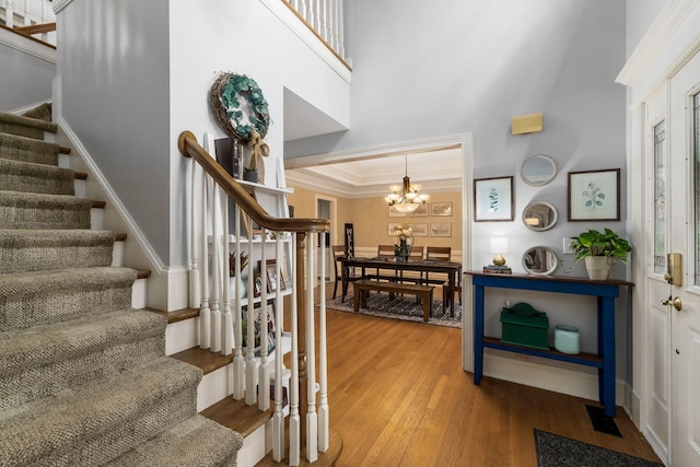1828 Bradford Cir, Newark, OH 43055 - stairway featuring a towering ceiling, wood finished floors, a chandelier, crown molding, and plenty of natural light