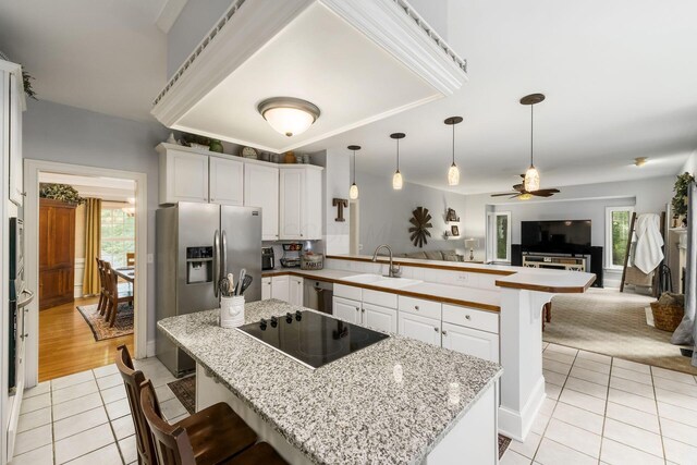 1828 Bradford Cir, Newark, OH 43055 - kitchen featuring black electric stovetop, stainless steel fridge, a peninsula, light tile patterned floors, and open floor plan