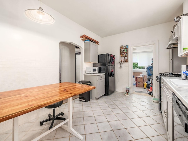 1482 Briarwood Ave, Columbus, OH 43211 - kitchen with white microwave, freestanding refrigerator, light countertops, arched walkways, and stainless steel dishwasher