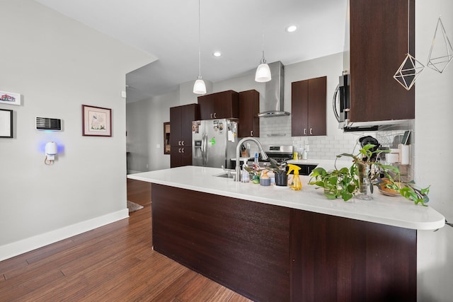 144 Wilson Ave, Columbus, OH 43205 - kitchen featuring wall chimney exhaust hood, appliances with stainless steel finishes, a peninsula, light countertops, and tasteful backsplash