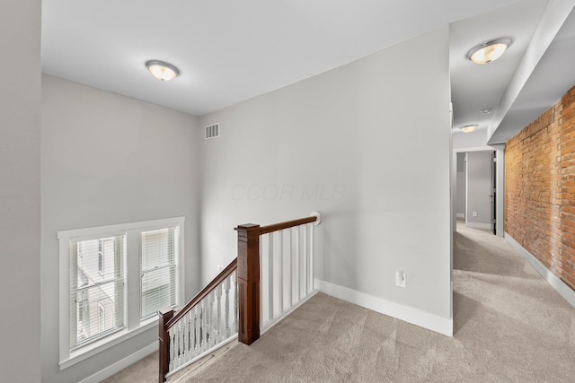144 Wilson Ave, Columbus, OH 43205 - hallway featuring an upstairs landing, carpet, and brick wall