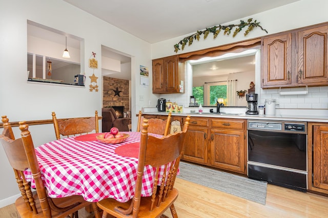 1374 Hanover Ct, Circleville, OH 43113 - kitchen with dishwasher, decorative backsplash, light wood-style floors, and brown cabinets